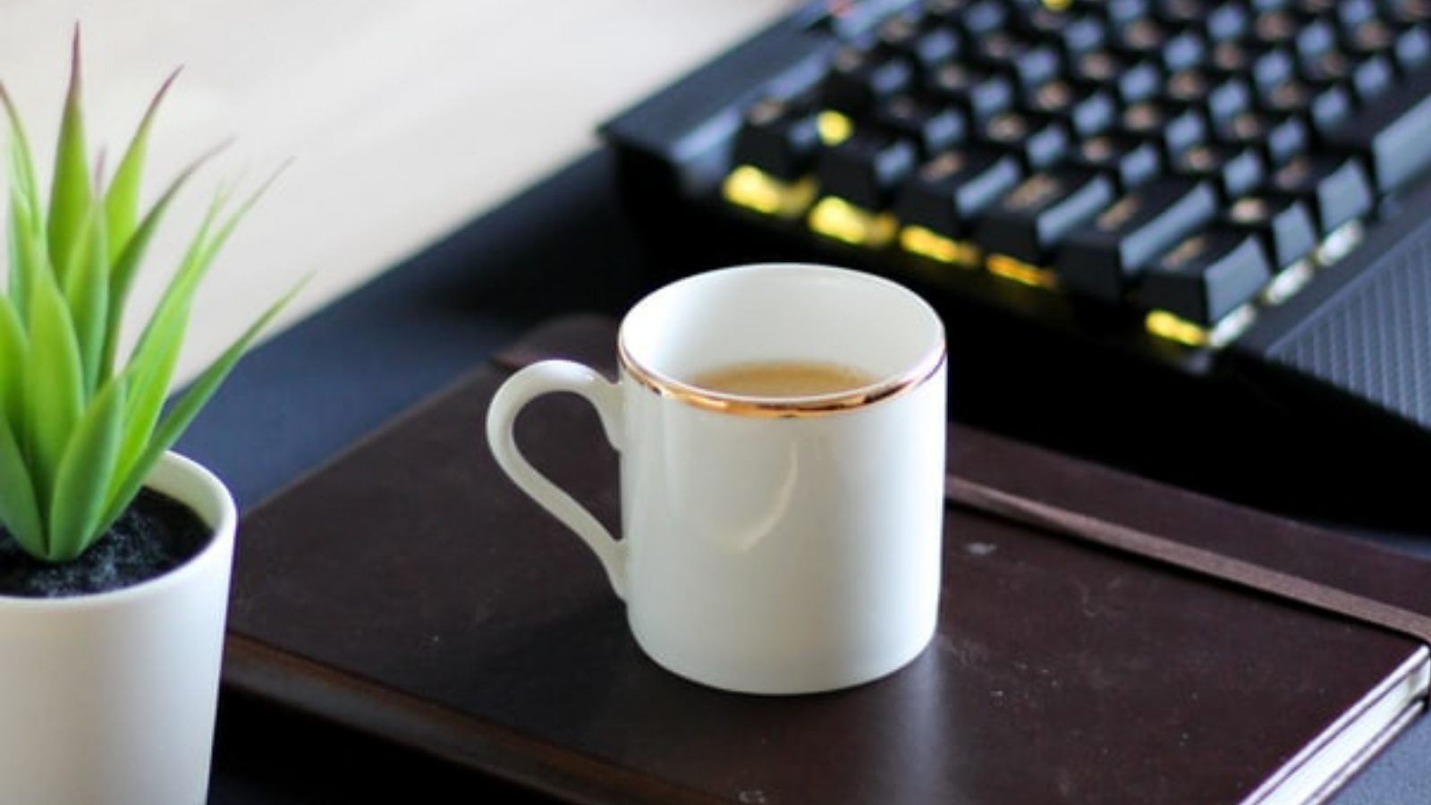 coffee cup next to a keyboard